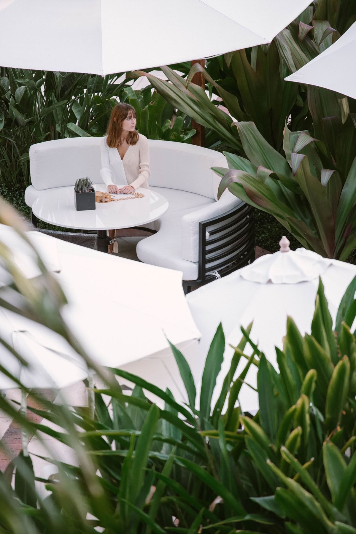 A girl sitting on a sofa in Café Boulud at Brazilian Court